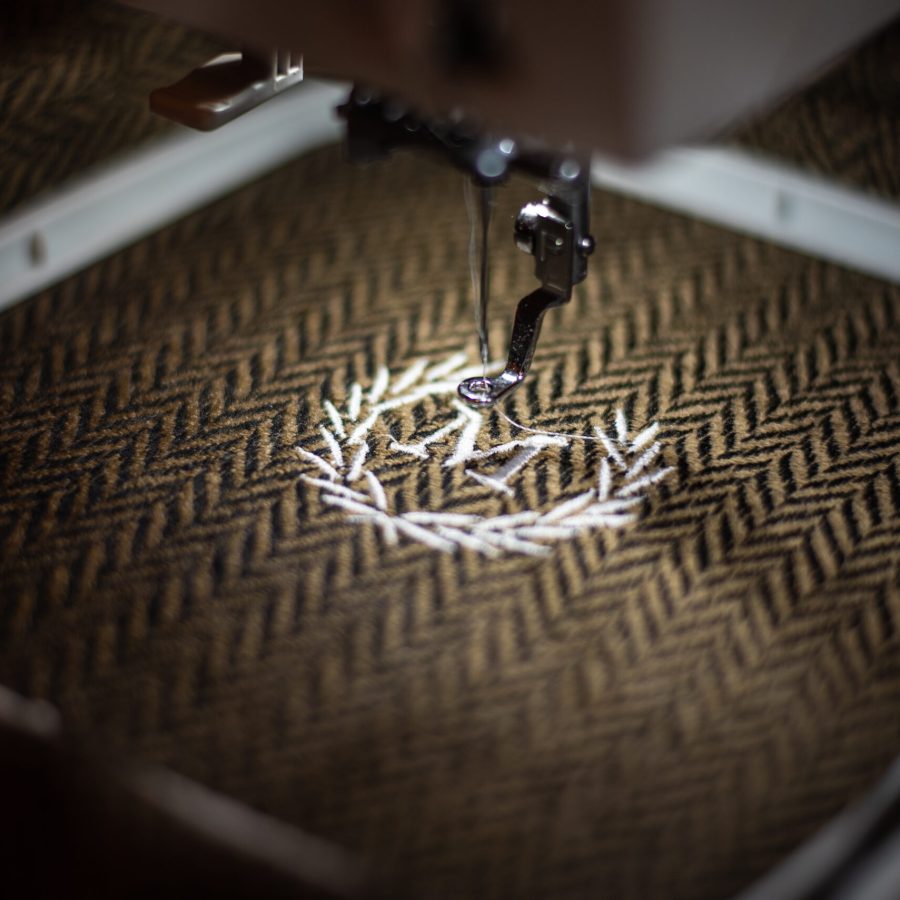 Embroidery design alphabet monogram M on brown fabrics embroider by machine. Close up